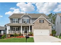 Charming two-story home with a welcoming front porch, two-car garage, landscaped yard and gray and brick exterior at 211 Serendipity Way, Dallas, GA 30157