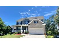Charming two-story home with a brick facade, front porch, two-car garage, and manicured lawn at 211 Serendipity Way, Dallas, GA 30157