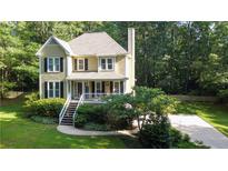 Aerial view of a house with a well-manicured lawn and mature trees at 51 Vienna Way, Douglasville, GA 30134