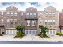 View of brick townhome with attached garages, manicured landscaping and inviting curb appeal at 3133 Quinn Pl, Atlanta, GA 30341