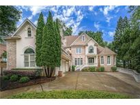 Elegant two-story home with manicured landscaping, brick accents and a circular driveway at 8630 Moor Park Run, Duluth, GA 30097