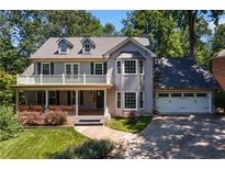Charming two-story home with a welcoming porch and manicured lawn, nestled among mature trees at 1180 Branch Water Ct, Dunwoody, GA 30338