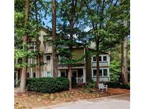 Inviting exterior of a multi-story condo surrounded by lush greenery and mature trees at 1416 Oakridge Cir, Decatur, GA 30033