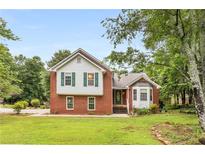 Charming brick home with green shutters and a well-maintained front yard on a sunny day at 524 Stephens Point Se Dr, Lawrenceville, GA 30045