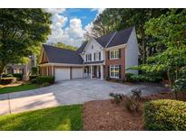 Charming two-story brick home with a large driveway and well-manicured landscaping at 1304 Carrington Way, Lawrenceville, GA 30044