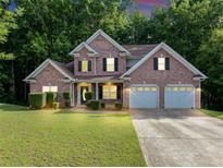 Charming two-story brick home with a well-manicured lawn and an attached two-car garage at 4375 Split Creek Dr, Douglasville, GA 30135