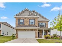 Charming two-story brick home with a well-manicured lawn and attached two-car garage at 6094 Whitetail Deer Run, Mableton, GA 30126