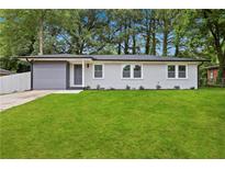 Charming single-story home with a well-manicured lawn and freshly painted white brick at 1770 Atherton Dr, Decatur, GA 30035