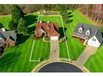 Beautiful aerial view of a red brick home with manicured lawn and long driveway on a large lot at 3076 Harris Mill Ct, Duluth, GA 30096