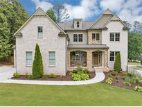Beautiful two-story brick home with a manicured lawn and stone porch at 3459 Clubland Dr, Marietta, GA 30068
