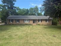 Charming brick ranch home features a well-manicured lawn and mature trees at 2266 Eastgate Dr, Snellville, GA 30078