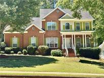 Inviting two-story brick home featuring manicured lawn and charming green shutters at 4630 Smokestone Dr, Douglasville, GA 30135