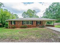 Charming single-story brick home featuring a covered carport and well-maintained landscaping at 5167 Hiram Lithia Springs Rd, Powder Springs, GA 30127