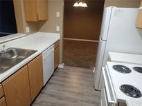 Galley kitchen featuring wooden cabinets, laminate countertops, and white appliances at 8202 Fairington Village Dr, Lithonia, GA 30038