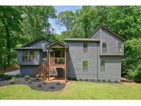 Charming two-story home featuring gray siding, wood porch and a beautifully landscaped yard at 3427 Mill Stream Sw Ln, Marietta, GA 30060