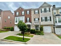 Charming brick and siding townhome featuring a well-manicured front yard and attached two-car garage at 3988 Church View Ln, Suwanee, GA 30024