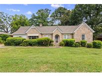 Charming stone home featuring a well-maintained lawn and mature landscaping at 5128 Lavista Rd, Tucker, GA 30084