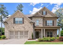 Inviting two-story home with a two-car garage, stone accents, and professionally landscaped front yard at 3483 Addilyn Ne Ct, Marietta, GA 30066