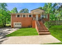 Charming brick home featuring a well-maintained front yard and inviting entrance stairs at 14301 Veterans Memorial Highway, Villa Rica, GA 30180