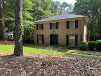 Charming two-story brick home with black shutters and a well-manicured lawn at 2315 Hudson Sw Dr, Lilburn, GA 30047