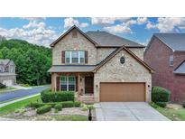Charming two-story brick home featuring a well-manicured front lawn and an attached two-car garage at 2425 Delamore Chase, Duluth, GA 30097