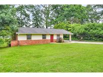 Charming single-story home featuring a well-manicured lawn, brick accents, and a convenient covered carport at 3395 Spring Dr, Atlanta, GA 30360