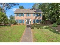 Charming brick home with blue shutters, mature trees, and a well-manicured lawn at 3999 Brintons Ml, Marietta, GA 30062