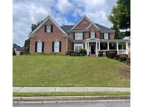 Charming two-story brick home with a large front yard and inviting covered porch at 2123 Floral Ridge Dr, Dacula, GA 30019