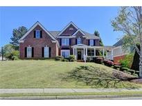 Inviting brick two-story home featuring a welcoming porch and lush front yard at 2123 Floral Ridge Dr, Dacula, GA 30019