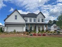 Beautiful new construction featuring a painted brick facade, covered entry and well manicured lawn and flower beds at 750 Keystone Dr, Woodstock, GA 30188