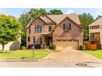 Beautiful two-story brick home with well-manicured lawn, mature trees, and a two-car garage at 6175 Beaver Crossing Dr, Cumming, GA 30040