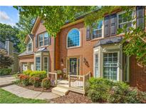 Charming brick home featuring a welcoming porch and manicured landscaping at 1313 Cobblestone Ln, Woodstock, GA 30189