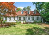 Charming white home featuring a brick-red roof, dormer windows, and well-maintained front yard at 1482 N Decatur Ne Rd, Atlanta, GA 30306
