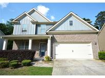Charming two-story home featuring a brick facade, blue siding, and a two-car garage at 2307 Overlook Ave, Lithonia, GA 30058