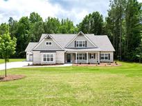Inviting single-story home with a brick facade, gabled roof, and well-manicured lawn and professional landscaping at 2109 Ella Springs Dr, Covington, GA 30014