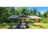 Charming brick home with a well-maintained front yard and mature trees providing ample shade at 2663 Washington Nw St, Atlanta, GA 30318