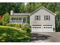 Charming home features a two-car garage, covered front porch, and lush landscaping at 12 Ranger Se Rd, Cartersville, GA 30121