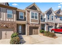 Charming townhome with stone accents, well-maintained landscaping, and attached garages at 2309 Rolling Trl, Lithonia, GA 30058
