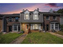 Charming townhome with brick facade, dormer windows, and inviting front lawn at 3244 Hampton Se Ct, Smyrna, GA 30082