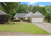 Charming ranch-style home with a well-maintained lawn, brick accents, and an attached two-car garage at 1027 Regency Dr, Acworth, GA 30102