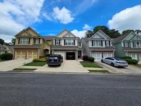 Inviting townhome exterior with a brick-accented garage and well-manicured lawns under a beautiful sky at 1067 Brownstone Dr # 23, Marietta, GA 30008