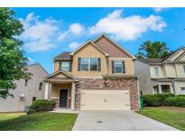 Charming two-story home with stone accents, a two-car garage and manicured lawn at 5123 Jack Dr, Decatur, GA 30035