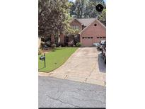 Charming brick home with a well-manicured lawn and a two-car garage, perfect for suburban living at 1593 Poplarwood Lane Northwest Ln, Lawrenceville, GA 30043