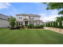 Beautiful two-story home with a well-manicured lawn, garden beds, and a welcoming entrance at 307 Cochin Dr, Woodstock, GA 30188
