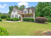 Charming two-story home featuring a landscaped front yard, covered porch, and appealing curb appeal at 4915 Lazy Creek Ct, Cumming, GA 30028