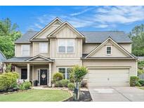 Charming two-story home featuring manicured lawn, neutral siding, a dark roof, and an attached two-car garage at 230 Haleys Ct, Woodstock, GA 30188