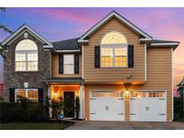 Charming two-story home with a two-car garage and inviting curb appeal against a vibrant sunset at 2584 Grayton Loop, Villa Rica, GA 30180