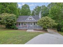 Charming home featuring a classic covered front porch and well-maintained landscaping at 402 Wood Chase Ln, Canton, GA 30114