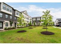 Charming townhomes with well-manicured lawn and young trees create an inviting curb appeal at 6635 Beacon Dr, Atlanta, GA 30328