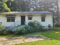Modest single-story home featuring a concrete drive, awnings, and small front yard at 449 Hamilton E Holmes Nw Dr, Atlanta, GA 30318
